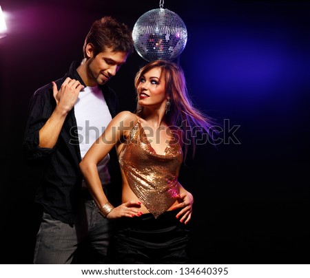 Pretty couple of young people dancing on a disco