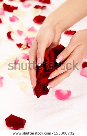 Closeup image of pink french manicure with leafs of rose