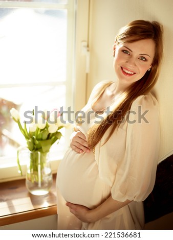 Happy Pregnant Woman With Hands On Her Belly