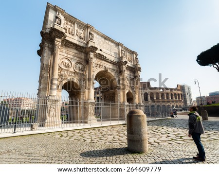 ROME, ITALY - MARCH 2015: tourist looks at Arch of Constantine in the center of the Rome, Italy in 2015. Arch of Constantin is located near world famous Colosseum in Rome.