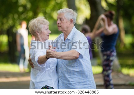 KOROLEV, MOSCOW REGION, RUSSIA - SUMMER, 2015: Smiling couple of old men and woman are dancing at open-air event at the city of Korolev, Moscow region, Russia, Summer, 2015