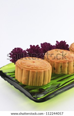 Moon cakes and purple chrysanthemum on white background.