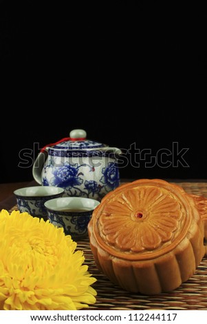 Moon cakes and tea, decorated with chrysanthemum on the mat