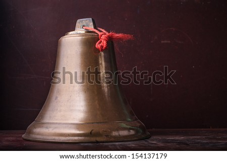 Bronze bell put on wooden table in dark room