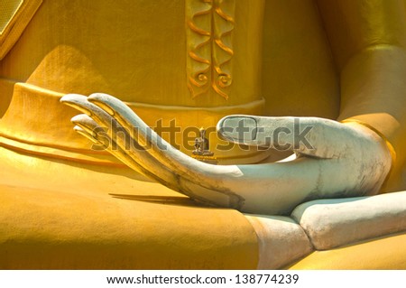 Little statue of the Buddha in the hand of big Buddha