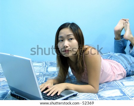 an asian girl thinking while in front of her notebook