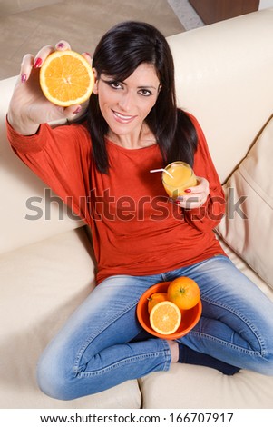 Young caucasian woman drink juice from orange with a straw