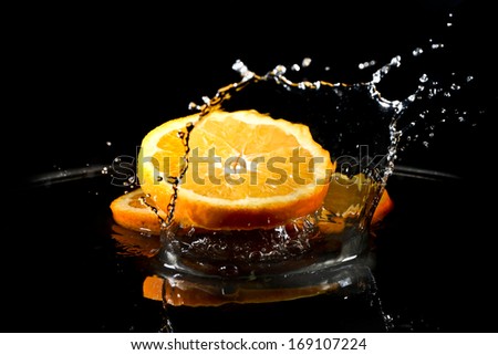 citrus fruit falling in water drops splashing everywhere. Concept of freshness and purity.