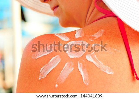 protective sun cream on a woman\'s shoulder