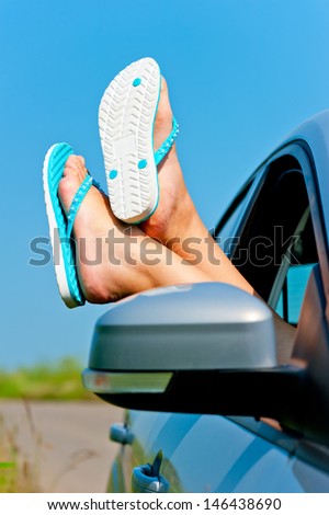 female legs dangling from the open car window in the shales