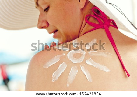Drawn sun sun cream on his shoulder a beautiful young woman