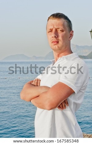 a man with a serious expression on his face is in a closed position against the sea