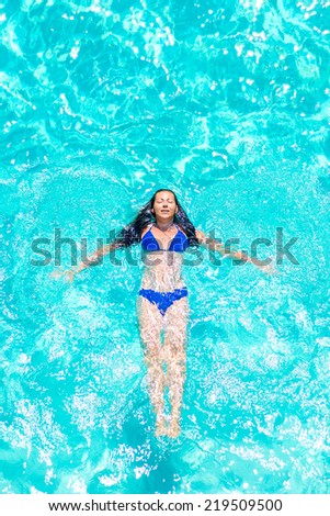 girl in a blue swimsuit floating on his back