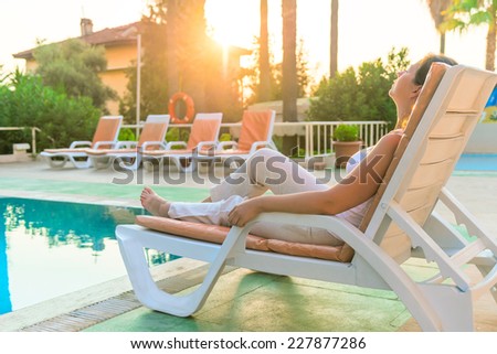woman sunbathing on a sun lounger in the morning sun