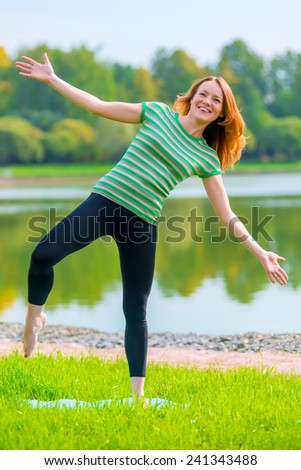 cheerful girl is trying to keep his balance on one leg