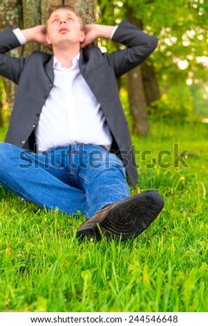 businessman relaxes on a green lawn