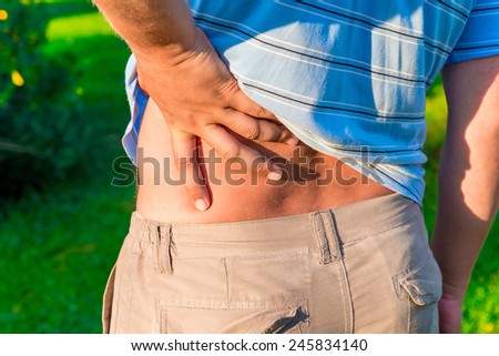 man holding his hand sore lower back