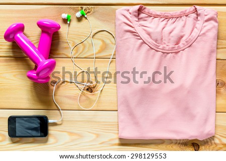 Clothing and dumbbells for sports girl shot from above