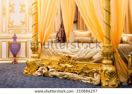 luxurious bedroom with four-poster bed to gold tones