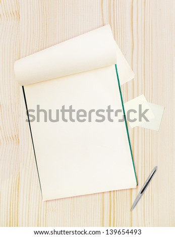 Blank notepad with pen on wood table, free space for text