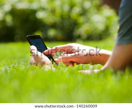 Man Using Mobile Smart Phone Outdoor In Summer