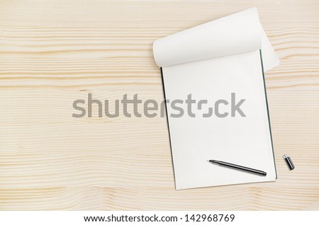 Blank notepad with pen on wood table, free space for text
