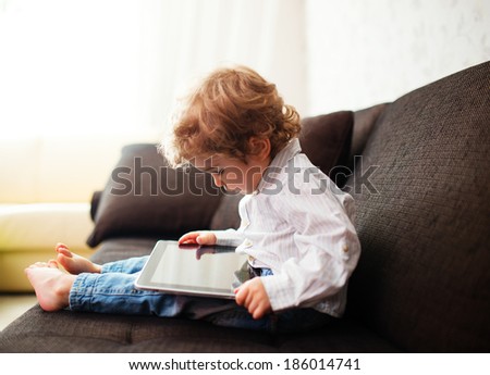Little boy watching a movie on tablet, indoor