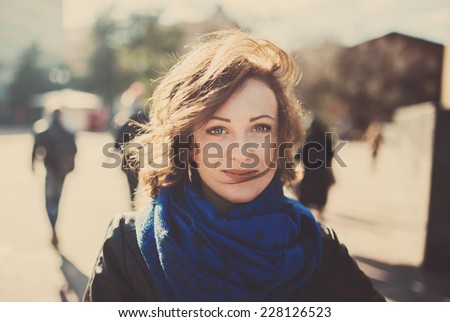 Portrait of a beautiful woman smiling in urban background, tinted photo
