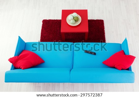Blue sofa with red pillows and red coffee table, top view