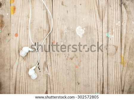 White modern portable audio earphones on wood