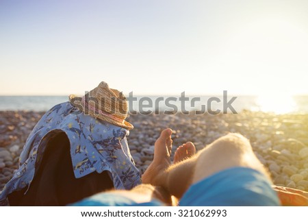 First person perspective of man legs on sunset beach. Travel concept