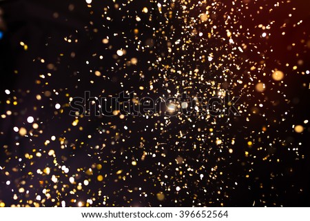 Christmas and holiday background. Golden glowing abstract glitter on black