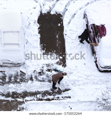 People cleaning the snow at parking area