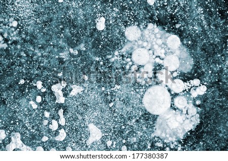 Ice background. Frozen air bubbles in thick ice texture.