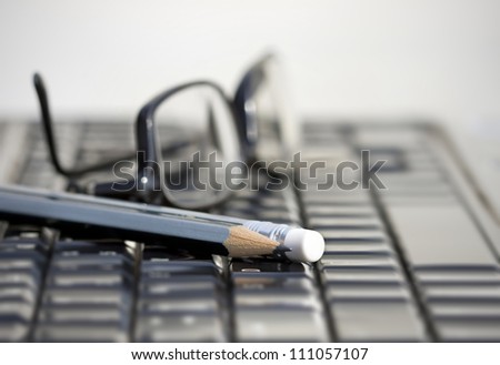 laptop keyboard and pencil and glasses
