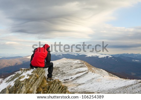 Lonely mountain climber on top of a mountain