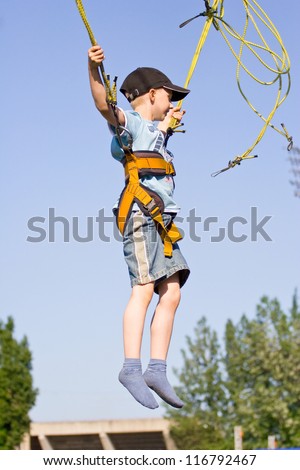 Little boy jumping on the trampoline (bungee jumping).