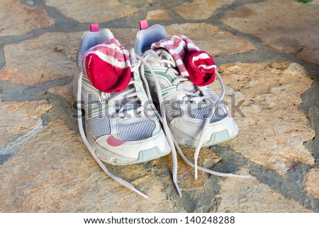 pair of old used running shoes with socks