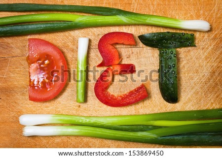 vegetables on the cutting board and word diet over wooden background