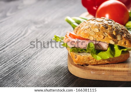 A fresh deli sandwich with ham, radish, tomatoes