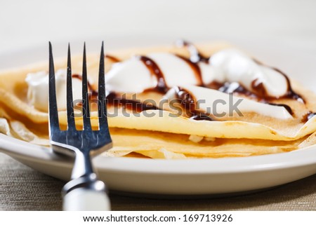 Close up of French style crepe with cream and chocolate sauce