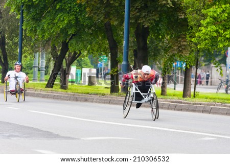 KRAKOW, POLAND - MAY 28 : Cracovia Marathon. Unidentified handicapped man in  marathon on a wheelchair on the city streets on May 18, 2014 in Krakow, POLAND