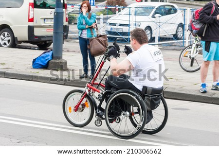 KRAKOW, POLAND - MAY 28 : Cracovia Marathon. Unidentified handicapped man in  marathon on a wheelchair on the city streets on May 18, 2014 in Krakow, POLAND