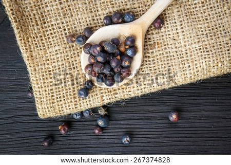 juniper berries on old wooden spoon