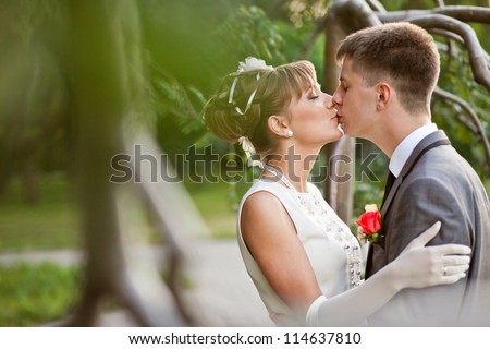 Wedding: Kissing wedding couple in spring nature close-up portrait