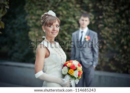 Wedding: Portrait of a young beautiful bride with a bouquet of spring garden in the hands of the groom is on the background - Copyspace