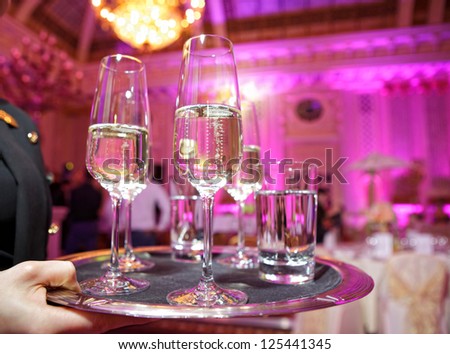 Waiter holding a tray, which is full of glasses of champagne