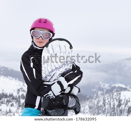 Young woman holding snowboard, she\'s looking away and smiling, copy space, close-up