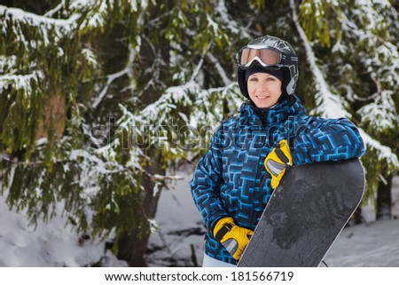 Young woman holding snowboard, she\'s looking away and smiling, copy space, close-up