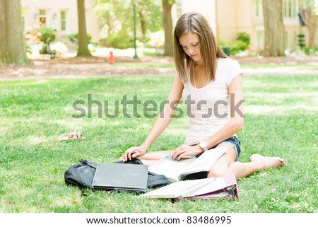 pretty young college or high school student with laptop and books